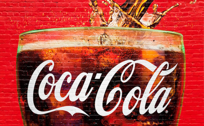 Atlanta, GA, - A glass full of Coca Cola painted in a old wall in Atlanta. The city is the home of Coca Cola. Photo via Shutterstock.