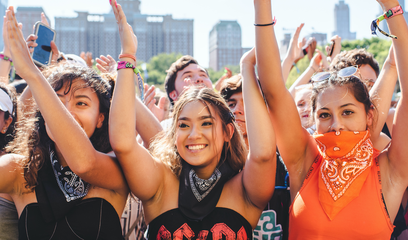 Chicago, Illinois - August 1st, 2019: Friends wait for a show to start at Lollapalooza in Grant Park, Chicago. Photo by Shutterstock.