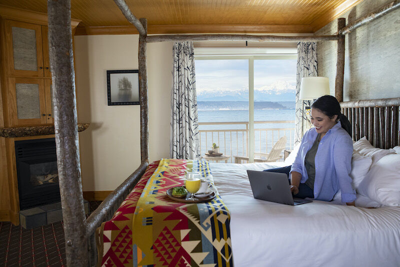 Woman working in a guest room at the Edgewater hotel in Seattle. Photo via the hotel.