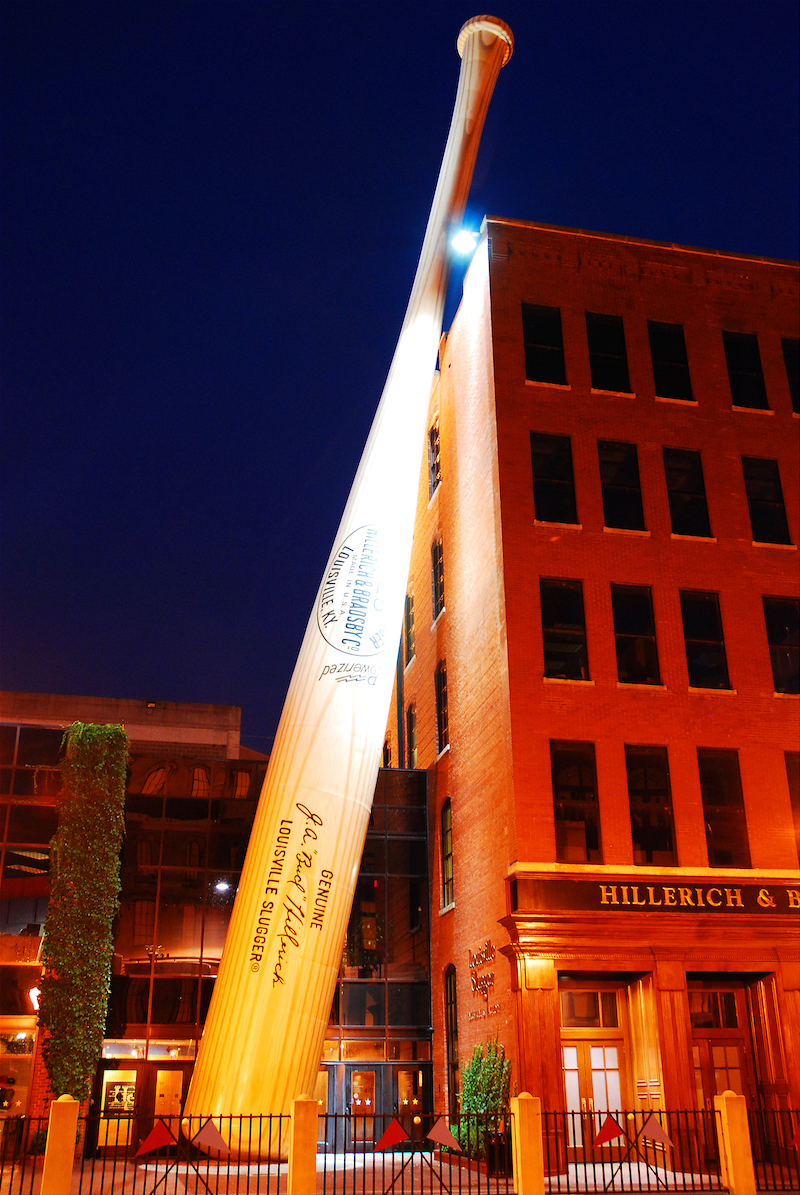 Louisville, KY, USA June 26 A five story baseball bat stands at the entrance of the Louisville Slugger factory and museum.  The sporting goods company has been manufacturing bats for 100 years. Photo vis Shutterstock.