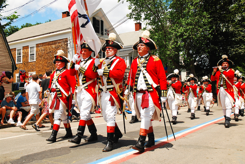 Bristol, RI, USA July 4 Adults dressed in British red coats from the American Revolution, march in a fourth of July parade in Bristol, Rhode island. Photo by Shutterstock.