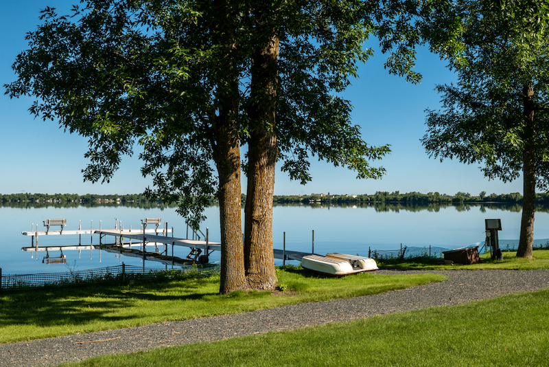 A paddle boat is upside down between a path and glassy water of Lake Irving, the first lake on the Mississippi river. Photo by Shutterstock.