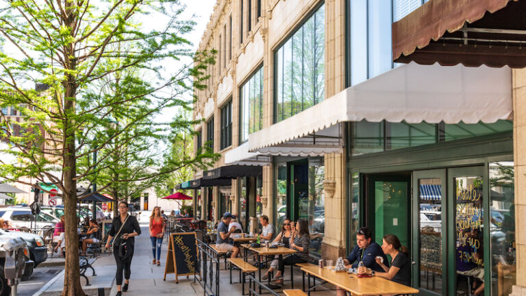 Asheville, NC - May 18, 2018: Diners relaxing on Page Ave. in downtown Asheville, NC, on a warm, sunny spring day. Photo via Shutterstock.