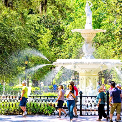 Savannah, Ga. Famous water fountain in Forsyth park, Georgia on sunny summer day with people walking by southern live oak with Spanish moss. Photo via Shutterstock.