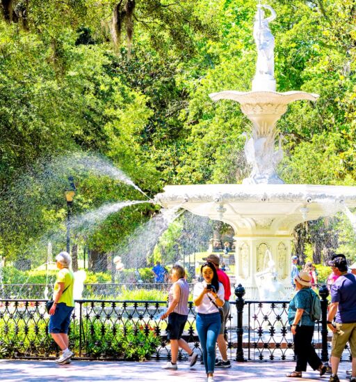 Savannah, Ga. Famous water fountain in Forsyth park, Georgia on sunny summer day with people walking by southern live oak with Spanish moss. Photo via Shutterstock.