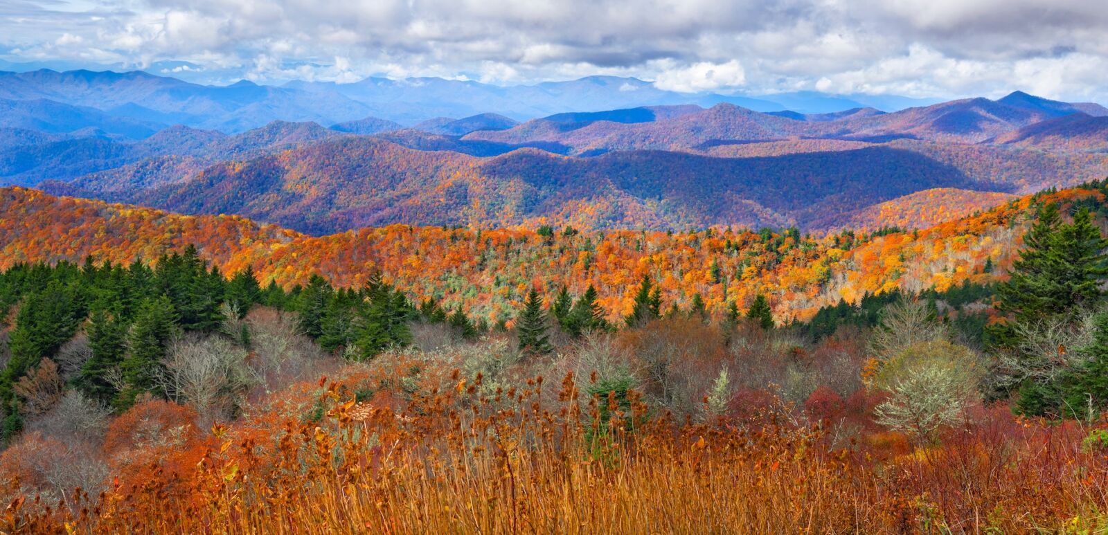 Beautiful autumn mountain panorama. Fall mountain scenery. A panoramic view of the Smoky Mountains from the Blue Ridge Parkway in North Carolina,USA. Image for banner or web header. Photo via Shutterstock.