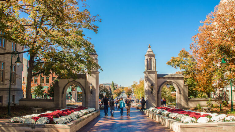 10-19-2019 Bloomington USA - University of Indiana - Family walks with college student out main gates of campus down into the town during Fall Break weekend. Photo via Shutterstock.