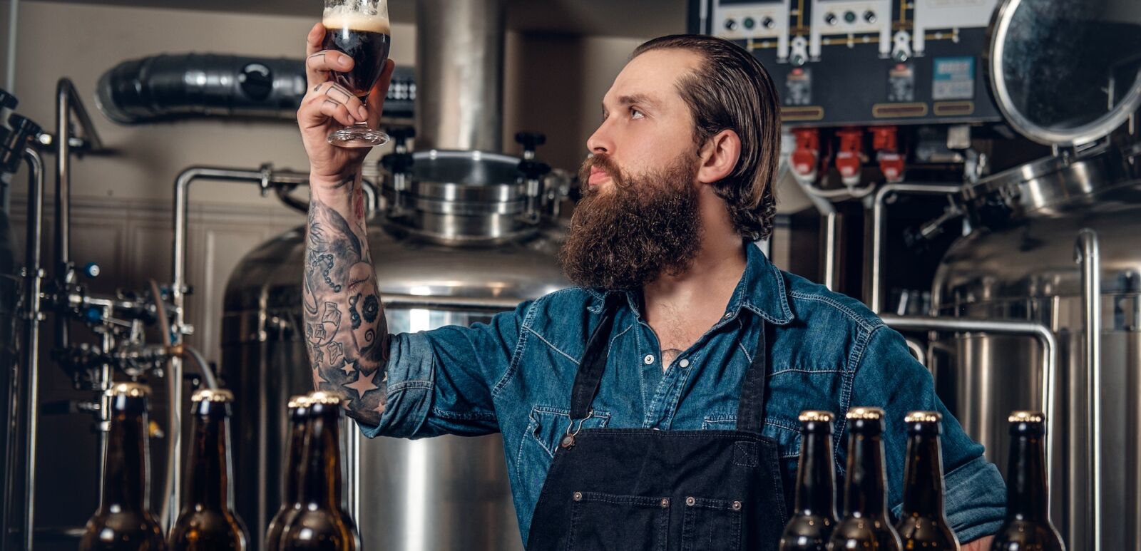 Pretentious beer guy stares at the beer in his hand. Photo via Shutterstock.