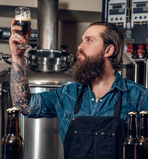Pretentious beer guy stares at the beer in his hand. Photo via Shutterstock.