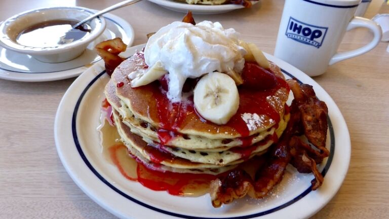 Ihop pancakes with bacon, banana maple surup and cream.