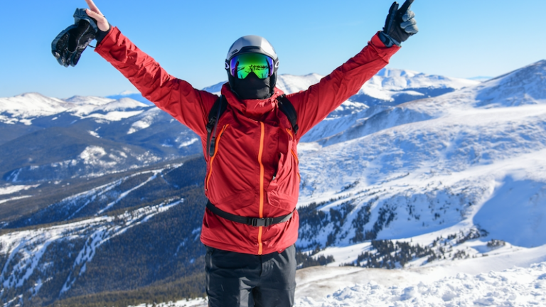 Excited skier standing on the top of the Peak 8 at Breckenridge Ski Resort, Colorado. Extreme terrain. Active lifestyle and winter vacation.