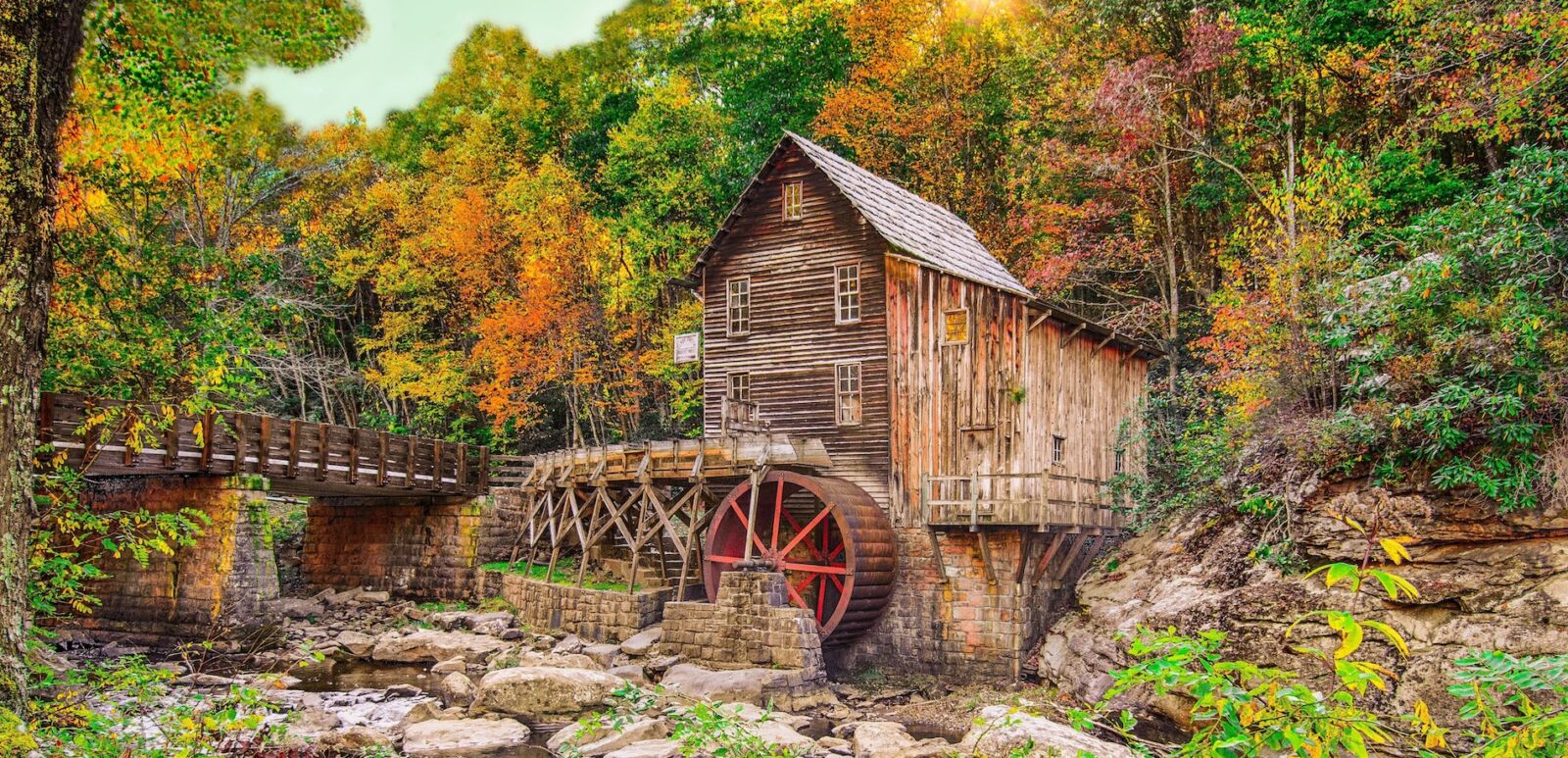 Autumn sun rays on fall foliage at Glade Creek grist mill at Babcock State Park near Fayetteville WV