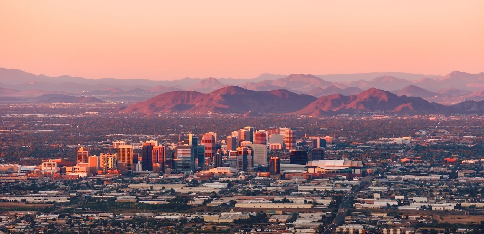 Phoenix, Arizona with its downtown lit by the last rays of sun at the dusk.