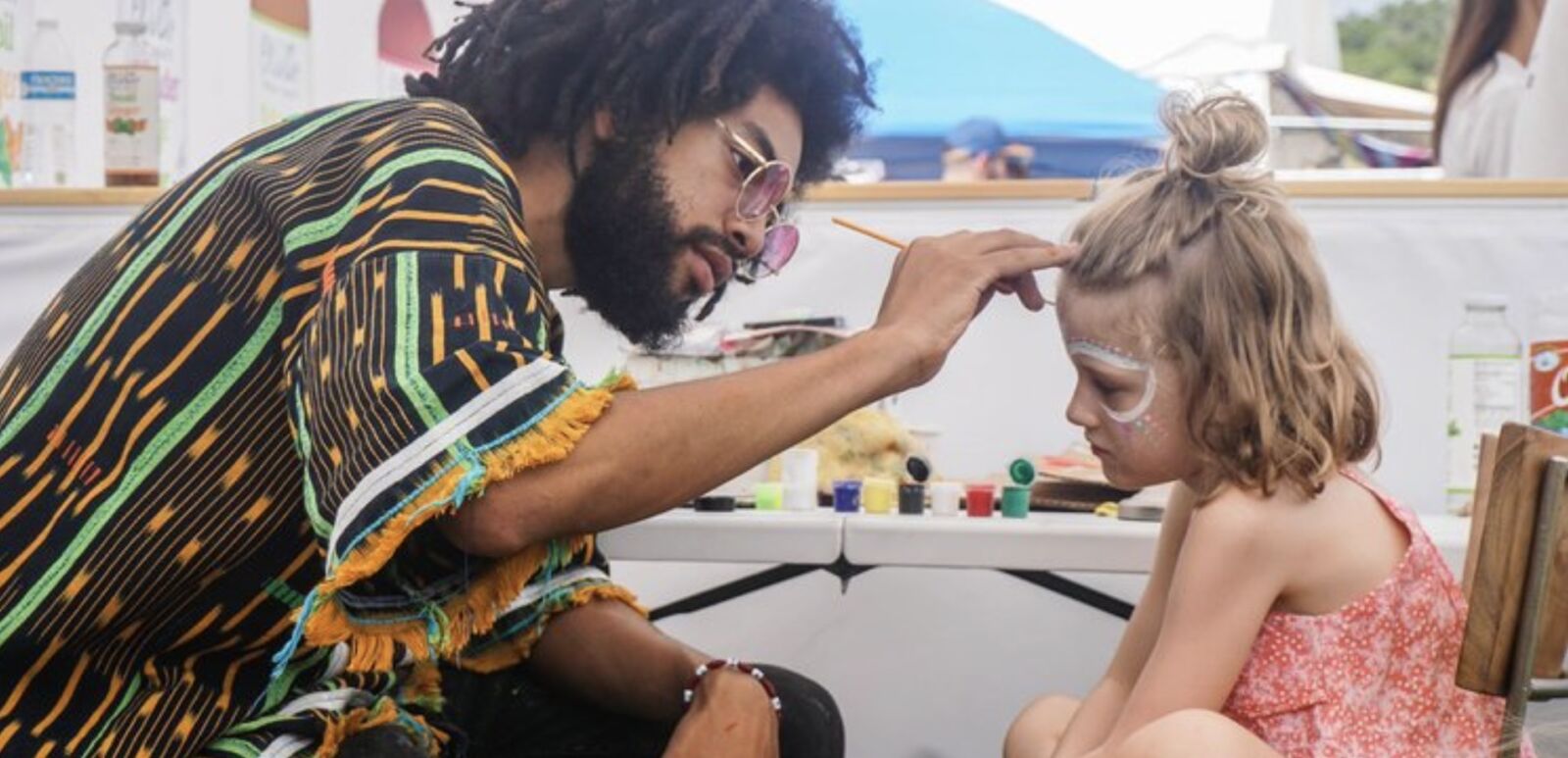 An artist paints a girl's face at Eclipse Utopiafest.