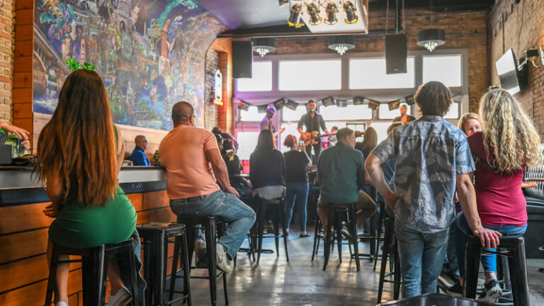 AUSTIN, TEXAS, USA - MARCH 17, 2019: Music bar on Sixth Street in Austin Texas during St Patricks day in March 2019. This historic street is famous for its live music bars. Photo via Shutterstock.